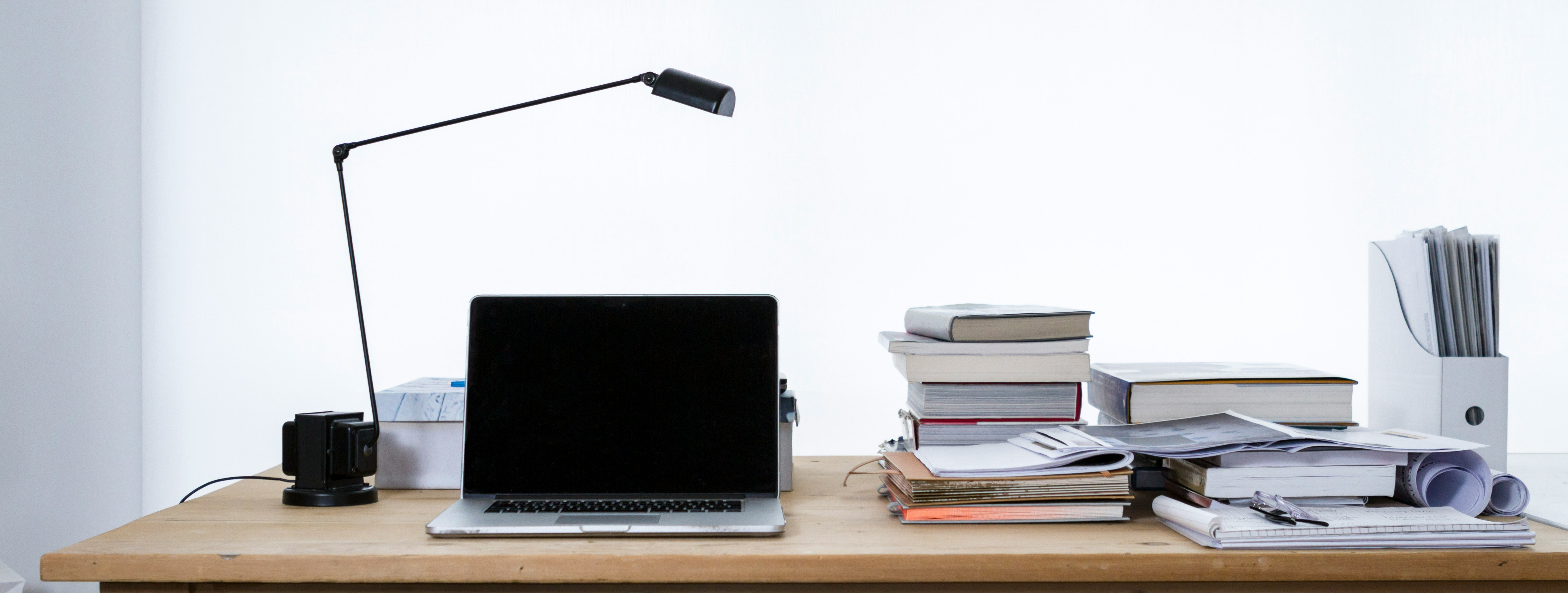 Schreibtisch mit Lampe, Laptop und Büchern