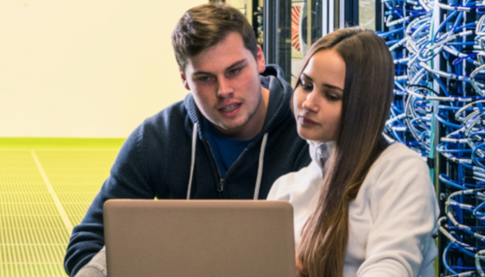 two students working with a laptop