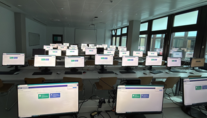 Moderner Computerraum mit zahlreichen Arbeitsplätzen und Monitoren.